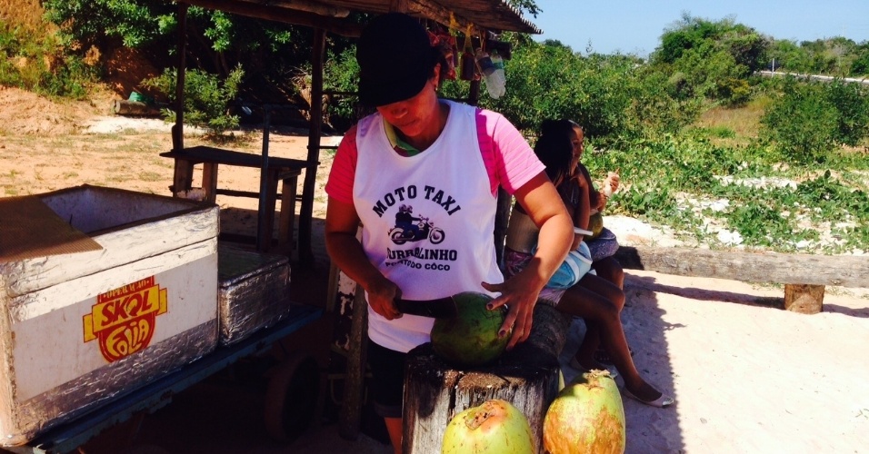 Maria corta cocos para servir aos clientes; ela era garçonete e decidiu vender cocos