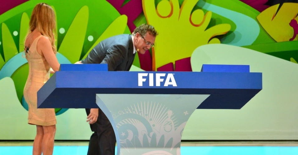 06.dez.2013 - Jérôme Valcke se abaixa para pegar uma bolinha que caiu no chão durante o sorteio dos grupos da Copa do Mundo