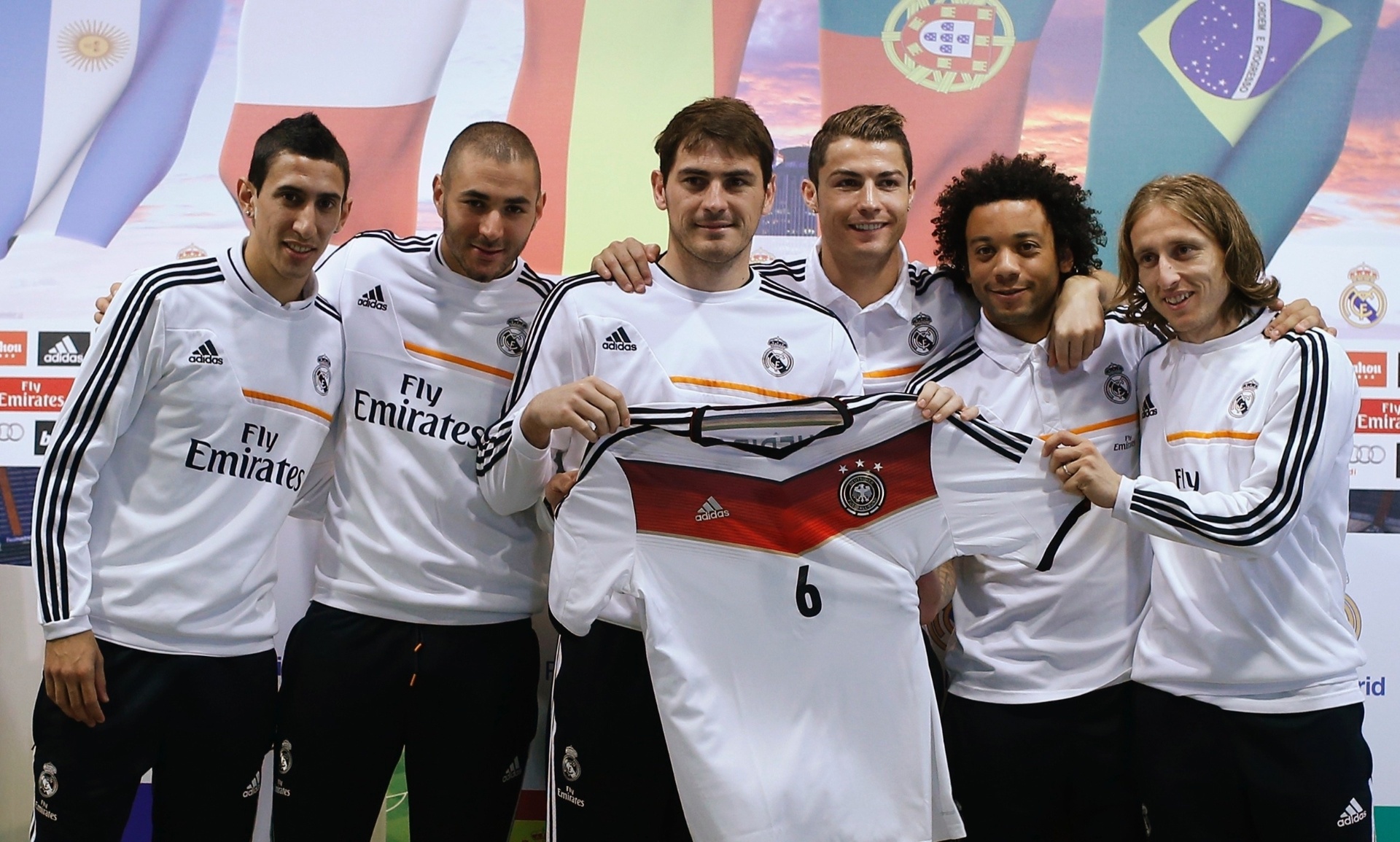 08.dez.2013 - Em homenagem ao colega Sami Khedira, que está lesionado e não compareceu à coletiva, os jogadores do Real Madrid mostram a camisa do craque da Alemanha - REUTERS/Javier Barbancho