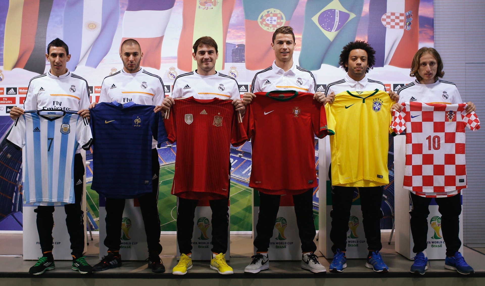 08.dez.2013 - Jogadores do Real Madrid posam com as camisas de suas seleções. Angel Di Maria, com a da Argentina; Karim Benzema, com a da França; Iker Casillas, com a da Espanha; Cristiano Ronaldo, com a de Portugal; Marcelo, com a do Brasil e Luka Modric, com a da Croácia - REUTERS/Javier Barbancho