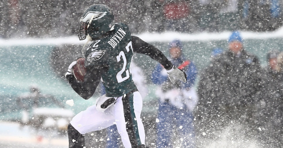 8.dez.2013 - Bradon Boykin, do  Philadelphia Eagles, carrega a bola em meio neve pesada que caiu durante o jogo