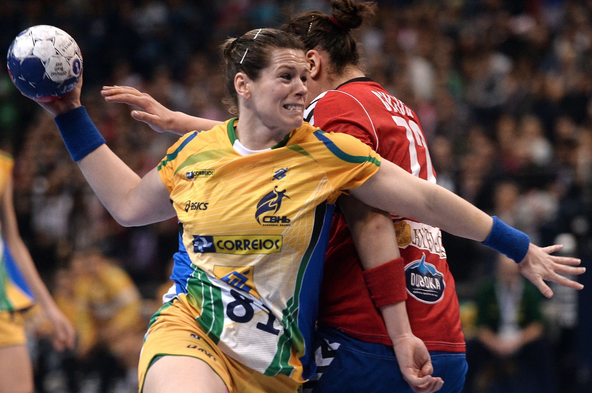 22.dez.2013 - Deonise, do Brasil, passa pela marcação sérvia antes de arremessar bola na final do Mundial de Handebol - AFP PHOTO / DIMITAR DILKOFF