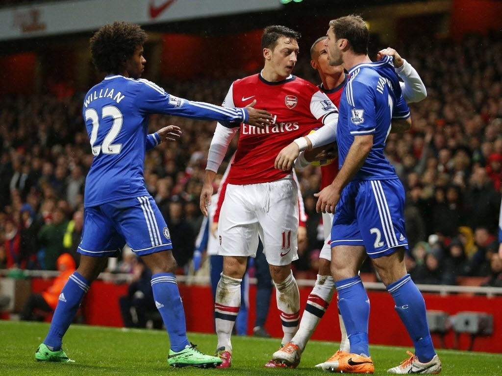 23.dez.2013 - Brasileiro Willian tenta separar briga entre o meia do Arsenal Mesut Özil e Branislav Ivanovic, do Chelsea, durante jogo do Campeonato Inglês