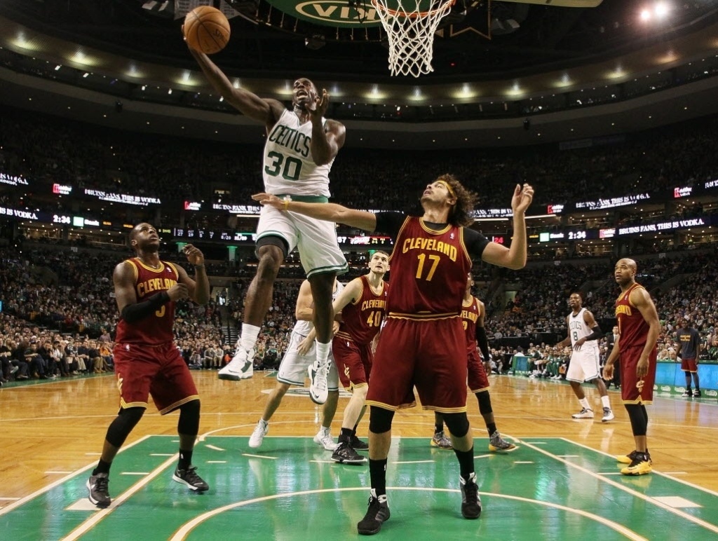 28.dez.2013 - Anderson Varejão, dos Cavs, observa Brandon Bass infiltrar e tentar bandeja para os Celtics, que venceram o duelo por 103 a 100