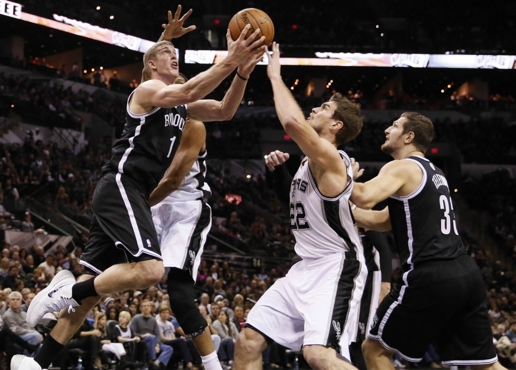 01.jan.2013 - Brasileiro Tiago Splitter, do San Antonio Spurs, disputa a bola com dois jogadores do Brooklyn Nets, em partida da NBA