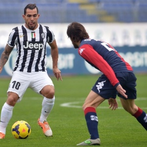 12. jan. 2014 - Tevez e Daniele Dessena disputam jogada durante partida entre Juventus e Cagliari, pelo Campeonato Italiano - AFP PHOTO / GABRIEL BOUYS
