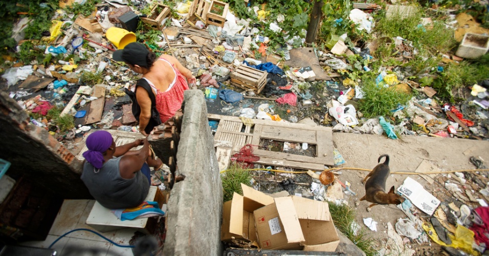 Mulheres em meio aos destroços de moradias destruídas em remoção na comunidade Metrô-Mangueira