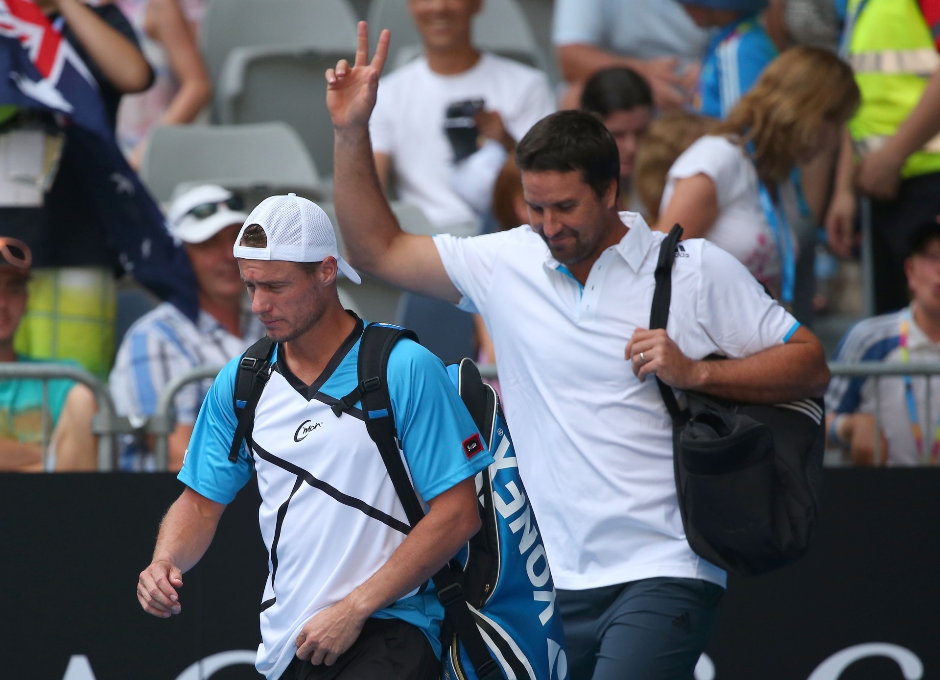 15.jan.2014 - Patrick Rafter (dir.) acena para torcida após jogar ao lado de Lleyton Hewitt contra Eric Butorac e Raven Klaasen, em partida do Aberto da Austrália - Scott Barbour/Getty Images