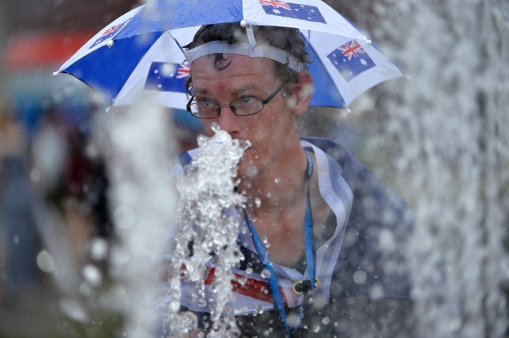 Australiano se refresca durante o terceiro dia de disputa no Aberto da Austrália - AFP PHOTO / SAEED KHAN