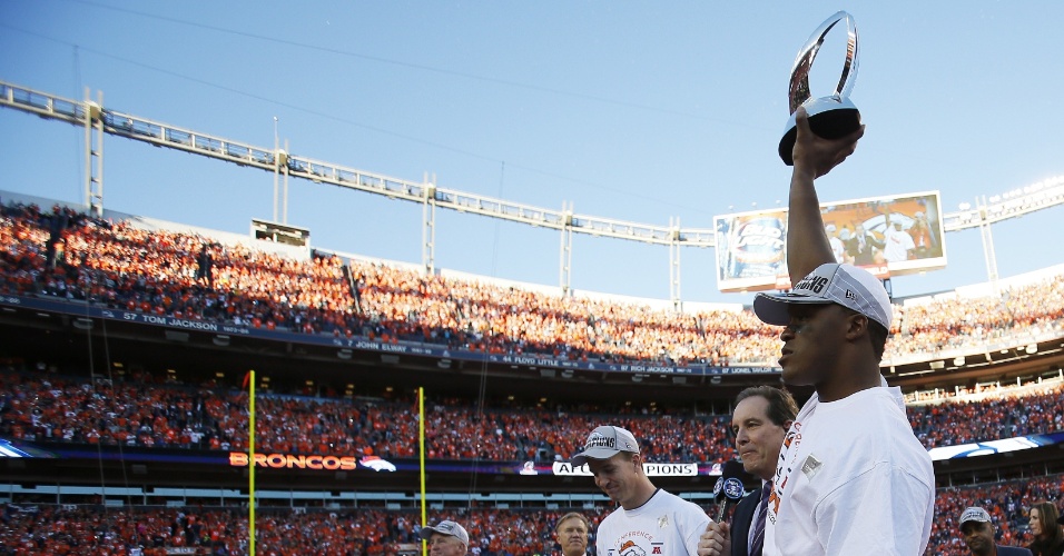19.jan.2014 - Demaryius Thomas ergue troféu de campeão da conferência americana da NFL conquistado pelo Denver Broncos sobre os Patriots