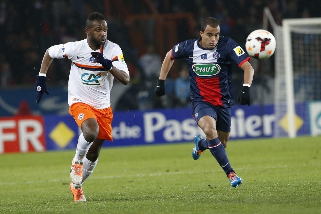 22.jan.2014 - Lucas tenta chegar na bola antes de Siaka Tiene, do Montpellier, durante jogo da Copa da França - AFP PHOTO / THOMAS SAMSON