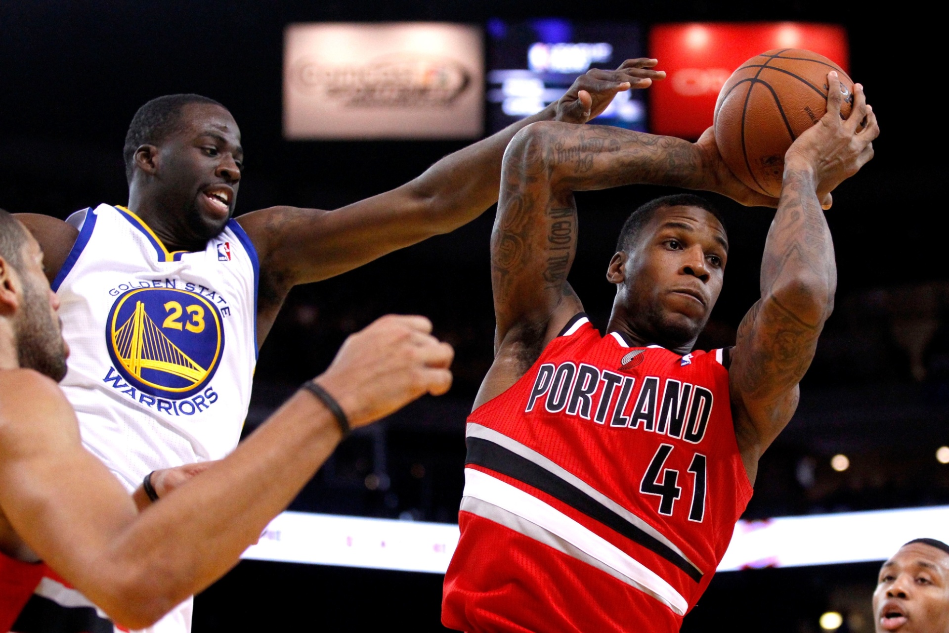 Thomas Robinson, do Portland Trail Blazers, tenta passar pela marcação de Draymond Green (esq.), do Golden State Warriors. Os Warriors venceram por 103 a 88