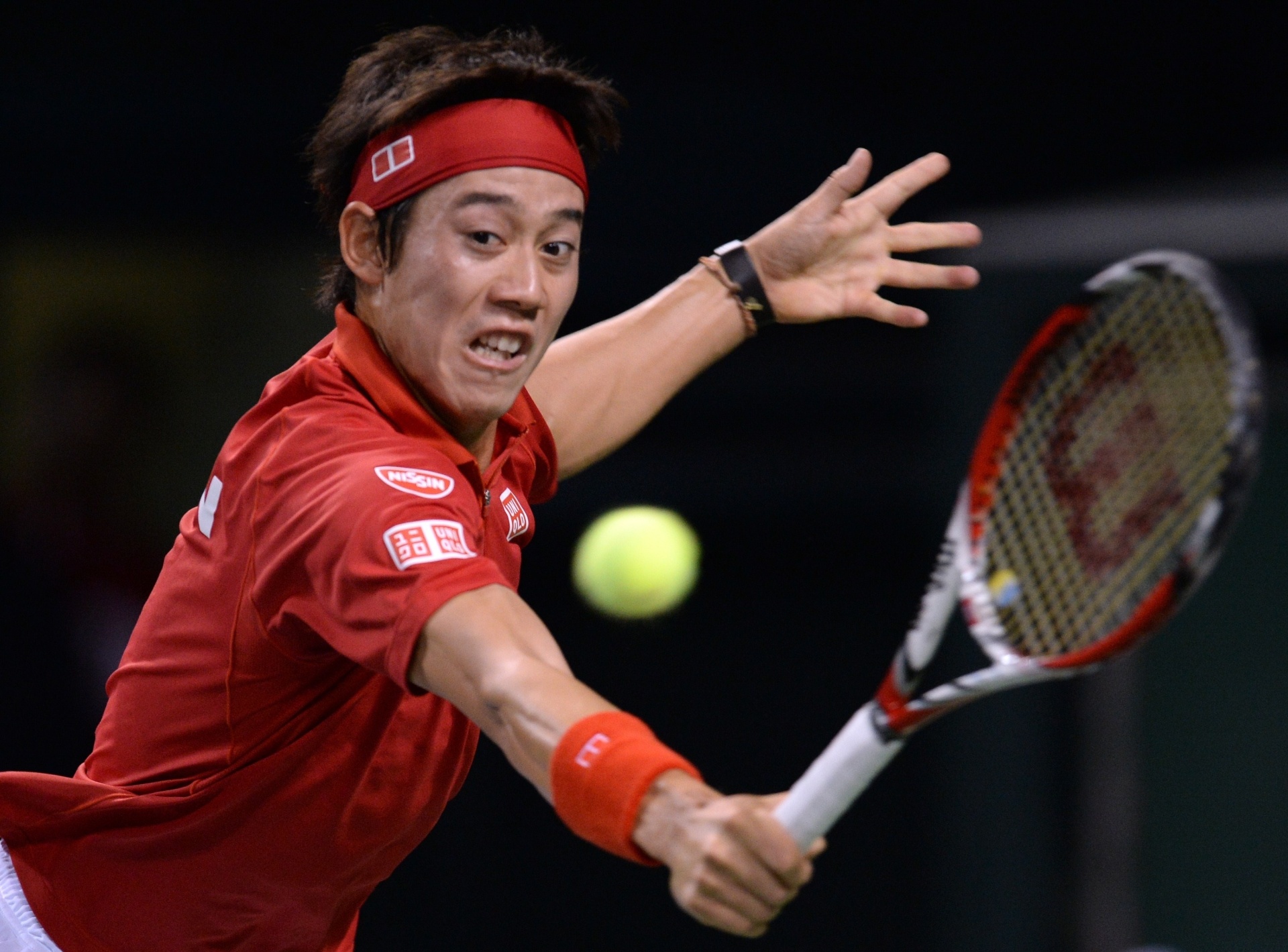 02.fev.2014 - Kei Nishikori, do Japão, rebate a jogada do canadense Frank Dancevic durante partida da Copa Davis