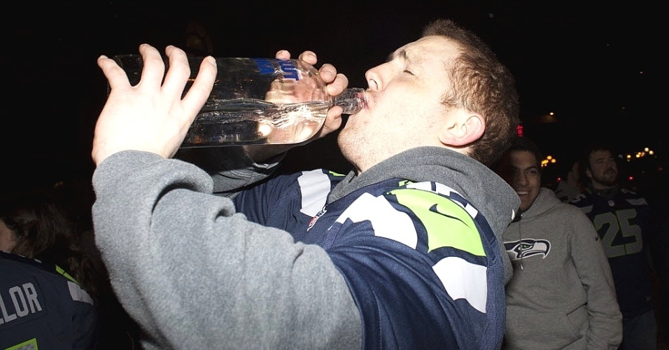 03.fev.2014 - Torcedor do Seattle Seahawks bebe um gole de vodca durante comemoração pelo título do Super Bowl