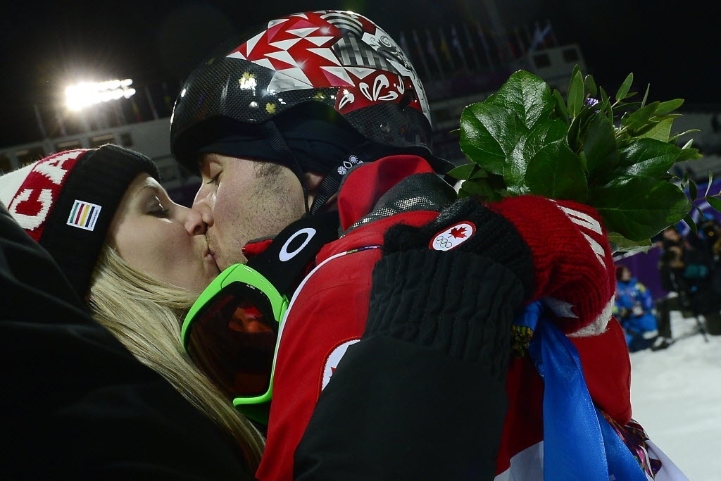 10.fev.2014 - Alex Bilodeau, canadense que levou o ouro no esqui estilo livre moguls, beija sua namorada Sabrina Bizier para celebrar a conquista - AFP PHOTO / JAVIER SORIANO