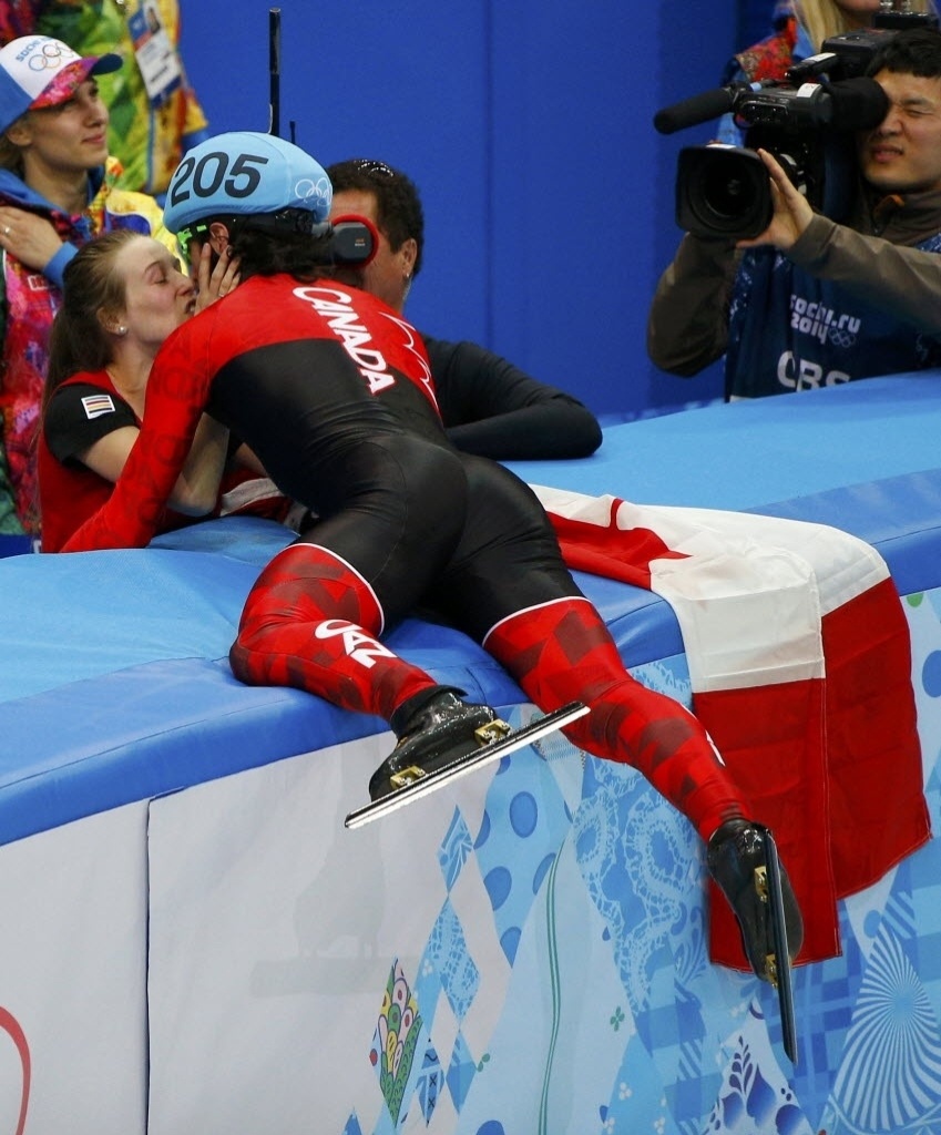 10.fev.2014 - O patinador em velocidade canadense Charles Hamelin pula mesa para beijar sua namorada (e também patinadora) Marianne St-Gelais após levar o ouro na prova de 1500 metros - REUTERS/Brian Snyder