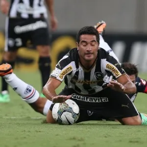 11.02.14 - Atacante Tanque Ferreyra é derrubado por jogador do San Lorenzo na partida do Botafogo pela Libertadores - EFE/Marcelo Sayão