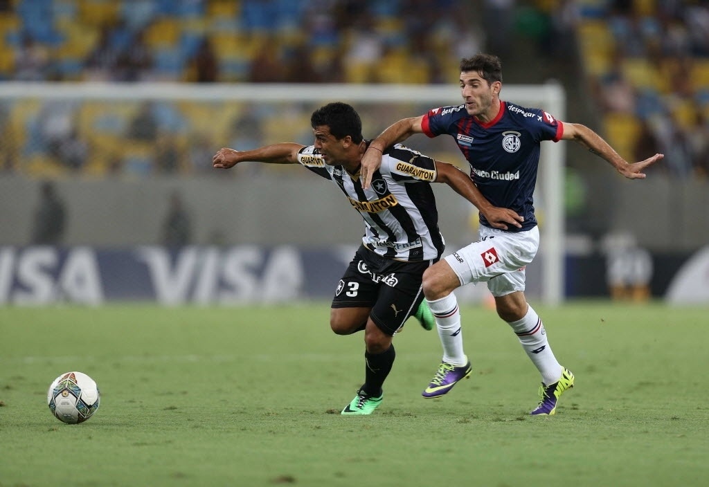 11.02.14 - Edilson disputa a bola com Ignacio Piatti no jogo entre Botafogo e San Lorenzo pela Libertadores - EFE/Marcelo Sayão