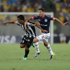 11.02.14 - Edilson disputa a bola com Ignacio Piatti no jogo entre Botafogo e San Lorenzo pela Libertadores - EFE/Marcelo Sayão