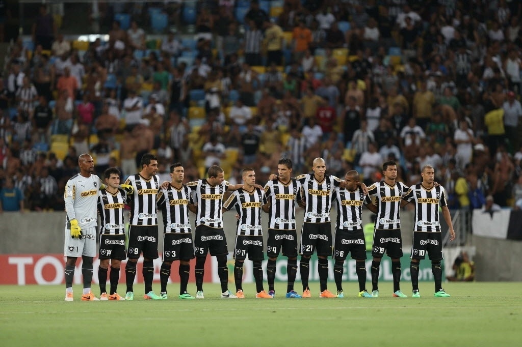 11.02.14 - Jogadores do Botafogo fazem um minuto de silêncio pela morte do cinegrafista Santiago Andrade antes de sua estreia na fase de grupos da Libertadores - EFE/Marcelo Sayão