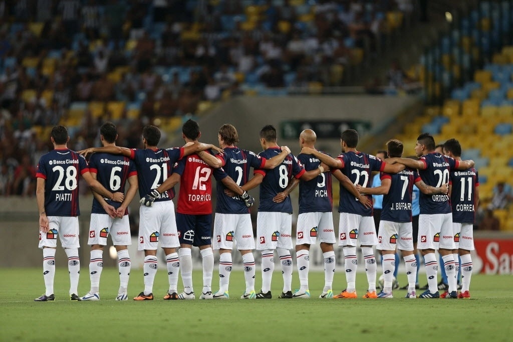 11.02.14 - Jogadores do San Lorenzo fazem um minuto de silêncio pela morte do cinegrafista Santiago Andrade antes de sua estreia na fase de grupos da Libertadores - EFE/Marcelo Sayão
