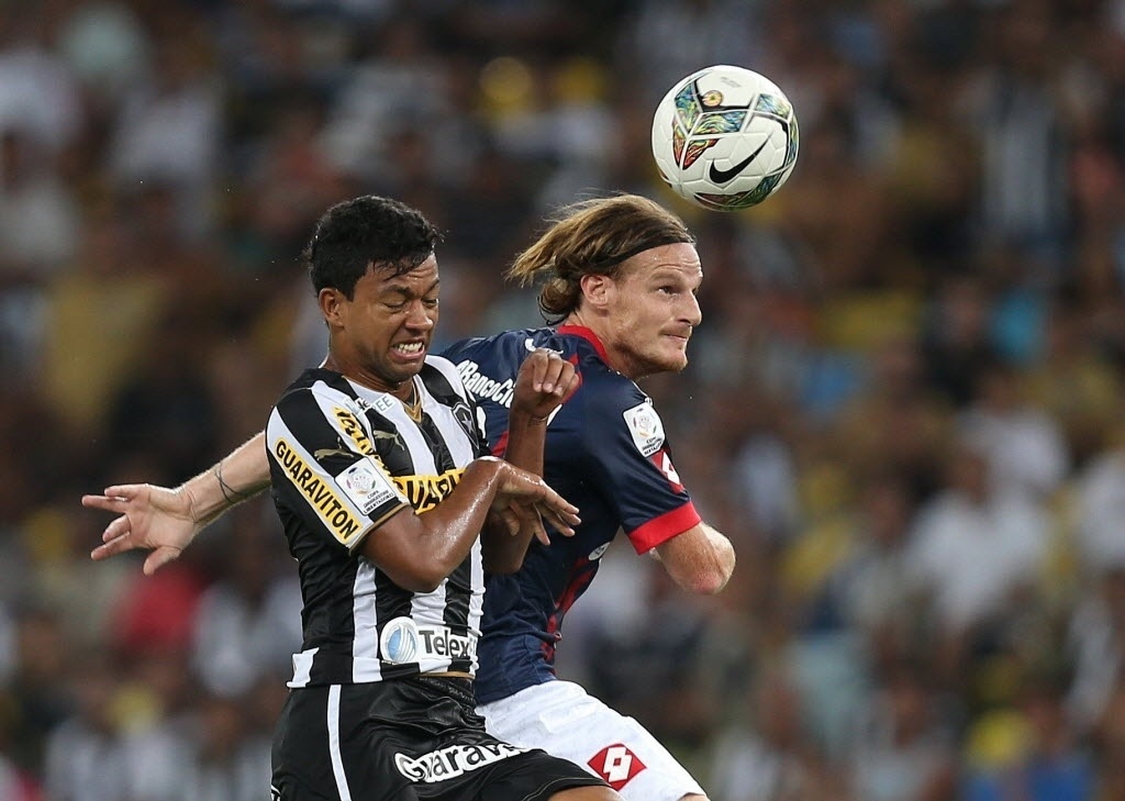 11.02.14 - Wallyson desvia bola de cabeça na partida entre Botafogo e San Lorenzo pela Libertadores - EFE/Marcelo Sayão