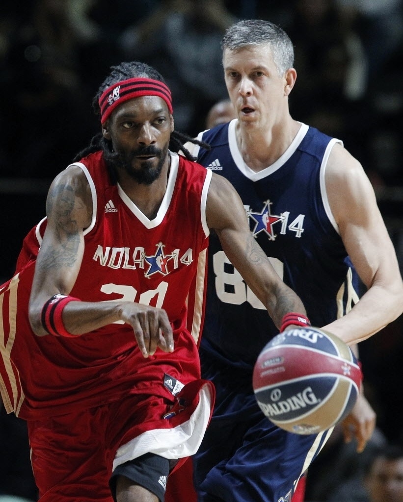 14.fev.2014 - O rapper Snoop Dogg chamou a atenção do público durante o Jogo das Celebridades do All-Star Game da NBA; atrás dele, Arnie Duncan, Secretário da Educação dos EUA e eleito MVP da partida - AP Photo/Bill Habe