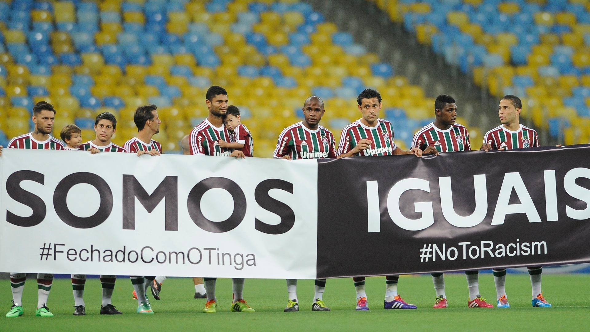 15.fev.2014 - Jogadores do Fluminense entram em campo com faixa em apoio a Tinga, alvo de racismo em jogo da Libertadores no Peru - Agência Photocamera