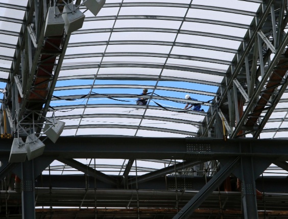 17.fev.2014 - Trabalhadores instalam cobertura do estádio, um dos avanços na obra requisitados pela Fifa para 18 de fevereiro