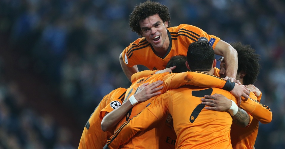 26.fev.2014 - Zagueiro luso-brasileiro Pepe pula sobre companheiros de Real Madrid para comemorar gol espanhol em goleada sobre o Schalke 04, na Alemanha, pela Champions
