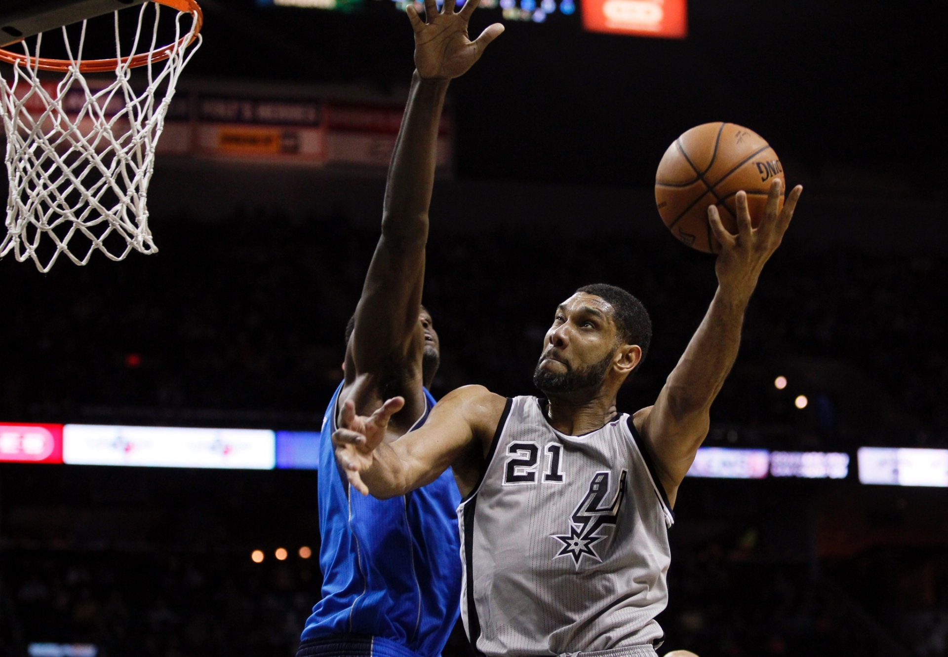 03.mar.2014 - Veterano Tim Duncan salta sobre a marcação do Dallas Mavericks para encestar bola para o San Antonio Spurs