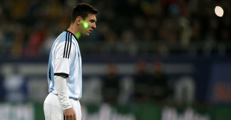 05.mar.2014 - Torcedores miram laser no rosto de Messi durante amistoso entre Argentina e Romênia, em Bucareste