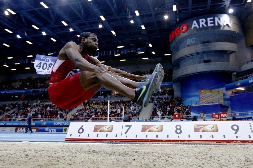 07.mar.2014 - Norte-americano Tyron Stewart compete na prova de salto em distância no Mundial Indoor de Atletismo, na Polônia - ADRIAN DENNIS/AFP