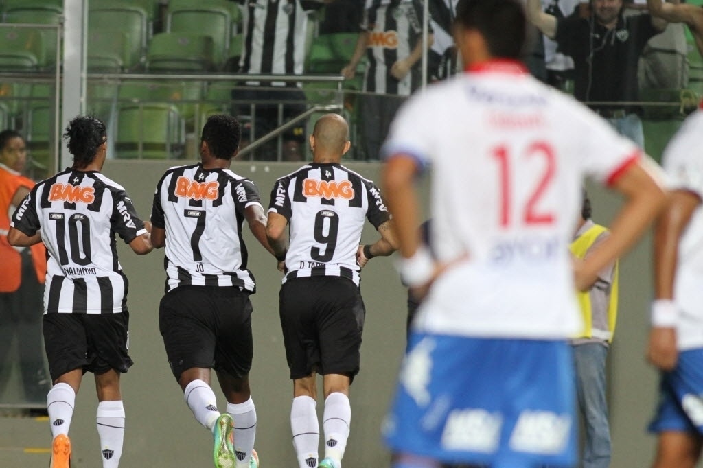 19.mar.2014 - Ronaldinho Gaúcho comemora com Jô e Diego Tardelli após abrir o placar de pênalti para o Atlético-MG contra o Nacional, do Paraguai - EFE/Paulo Fonseca