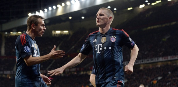 01.abr.2014 - Ao lado do brasileiro Rafinha, Schweinsteiger comemora gol de empate do Bayern de Munique contra o Manchester United - AFP PHOTO / CHRISTOF STACHE - AFP PHOTO / CHRISTOF STACHE