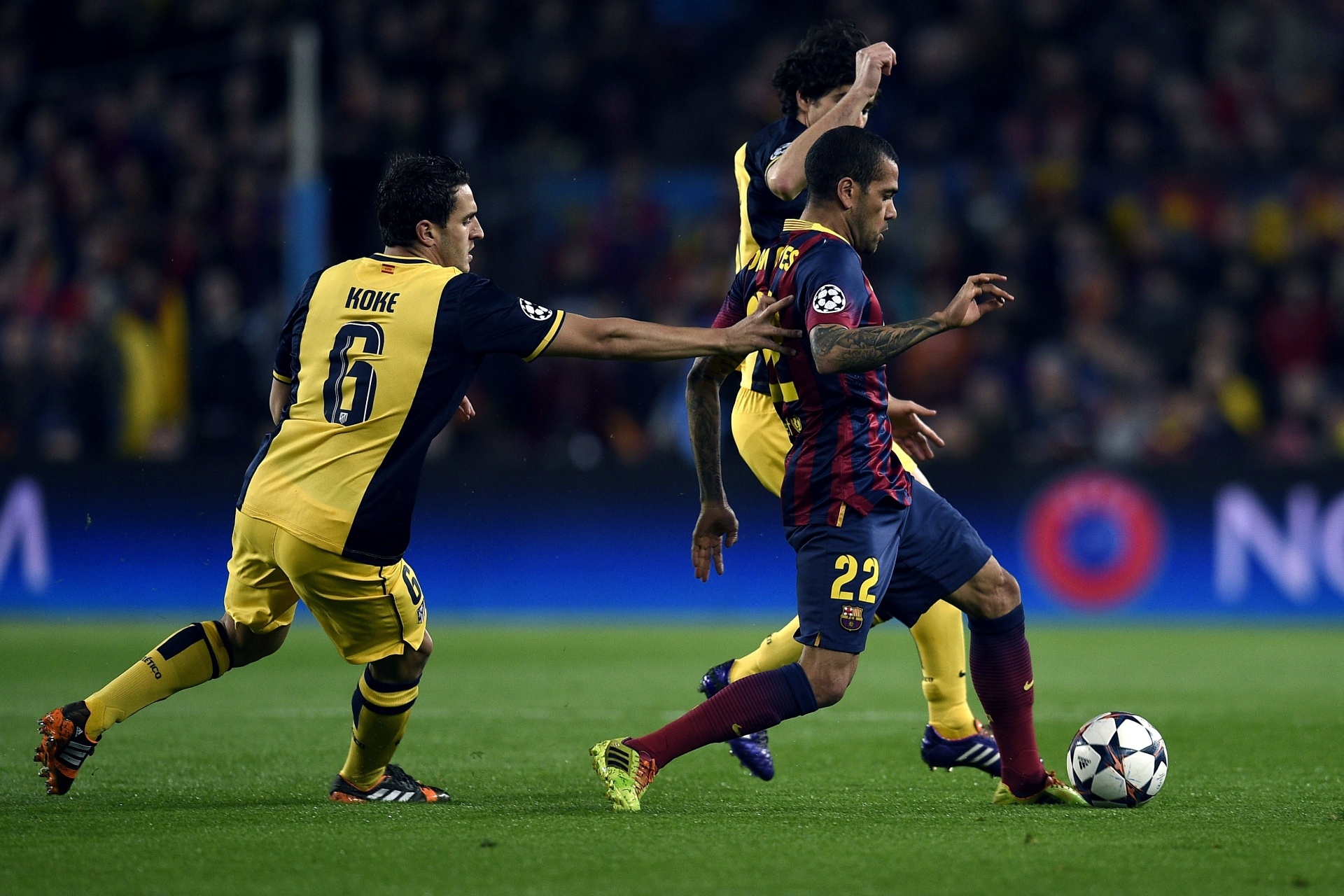 01.abr.2014 - Daniel Alves, do Barcelona, tenta escapar da marcação de Koke (esq), do Atlético de Madri, durante jogo pelas quartas de final da Liga dos Campeões - AFP PHOTO/ LLUIS GENE