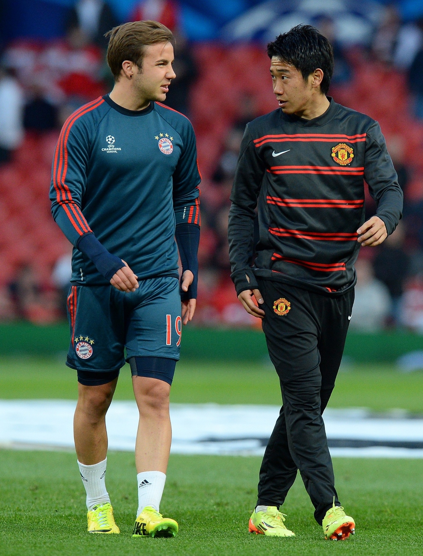01.abr.2014 - Shinji Kagawa (dir), do Manchester United, e Mario Gotze, do Bayern de Munique, conversam antes de duelo pela Liga dos Campeões. Os dois atuaram juntos no Borussia Dortmund - AFP PHOTO/ANDREW YATES