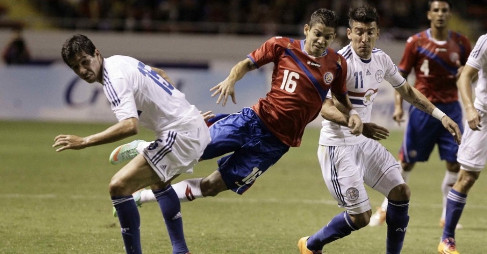 5.mar.2014 - Cristian Gamboa, da Costa Rica, sofre falta durante a vitória por 2 a 1 sobre o Paraguai em amistoso disputado em San José