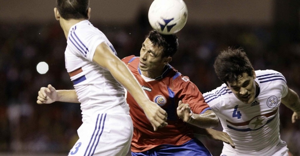 5.mar.2014 - Geancarlo González (c), da Costa Rica, ganha a disputa pela bola em lance da vitória por 2 a 1 sobre o Paraguai, em amistoso disputado em San José