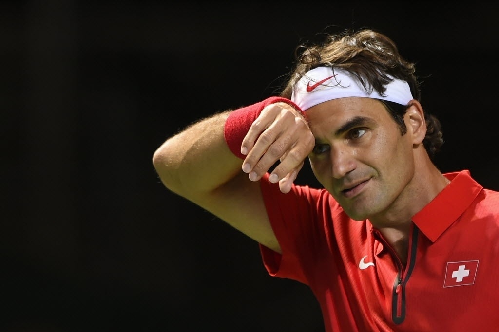 04.abr.2014 - Roger Federer enxuga o suor durante partida contra Mikhail Kukushkin