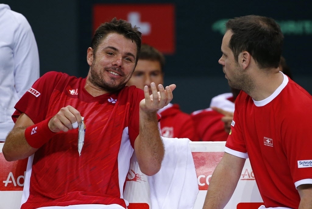 04.abr.2014 - Stanislas Wawrinka conversa com Severin Luethi, capitão da suíça, durante partida da Davis contra o Cazaquistão