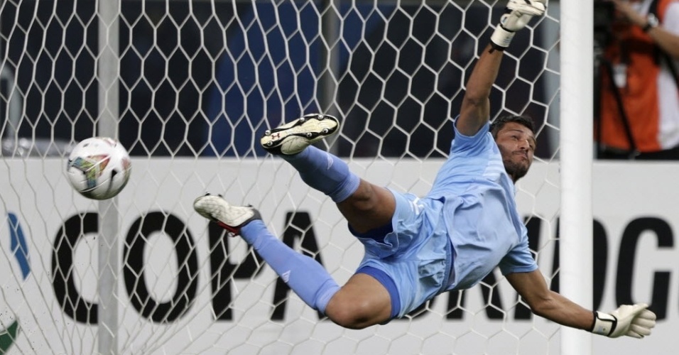 10.abr.2014 - Munúa tenta, mas não impede o gol de pênalti convertido por Barcos, que colocou o Grêmio na frente do placar contra o Nacional