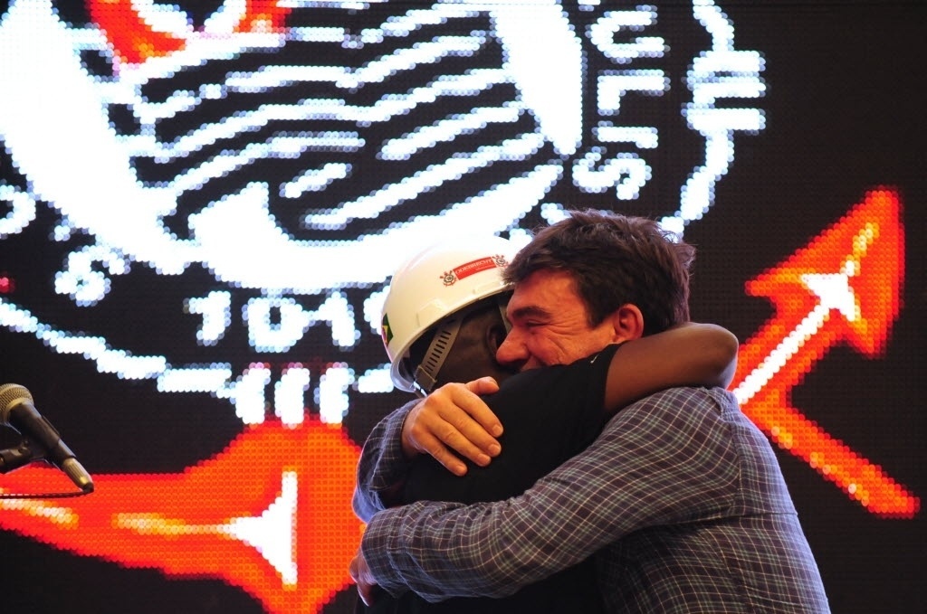 15.abr.2014 - Ex-presidente do Corinthians, Andrés Sanchez abraça operário do Itaquerão na cerimônia de entrega de posse do estádio ao clube paulista