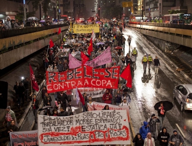 15.abr.2014 - Manifestantes seguram faixa pedindo para que o povo se rebele contra a Copa durante protesto em São Paulo