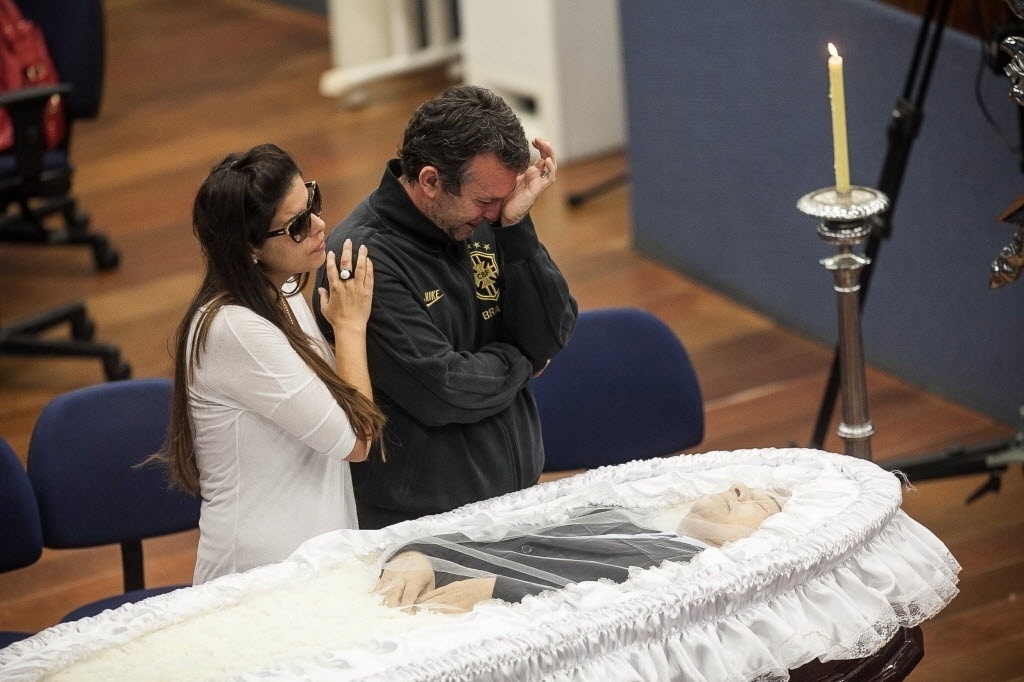 20.abr.2014 - Neto, comentarista da Bandeirantes, se emociona ao lado da viúva Flávia durante o velório do amigo Luciano do Valle - Rodrigo Capote/UOL