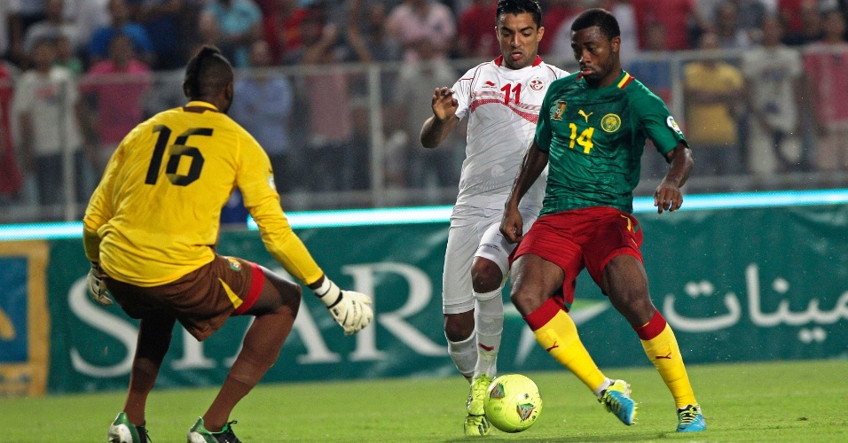 13.out.2013 - Aurélien Chedjou (d), de Camarões, briga pela disputa de bola durante a partida contra a Tunísia pelas eliminatórias da Copa do Mundo-2014