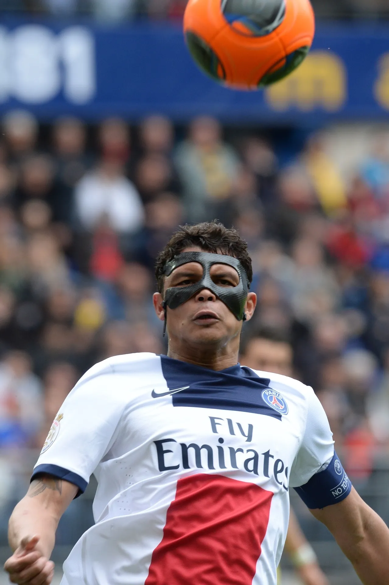 27.abr.2014 - Usando máscara protetora, brasileiro Thiago Silva disputa a partida entre PSG e Sochaux - AFP PHOTO / PATRICK HERTZOG