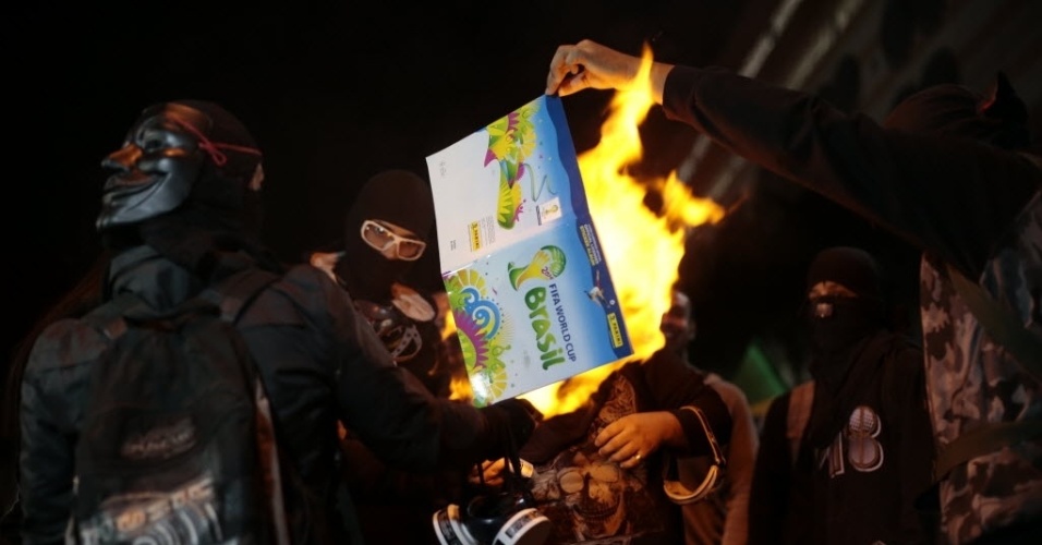 29.abr.2014 - Manifestantes queimam álbum de figurinhas em protesto contra a Copa do Mundo no bairro do Tatuapé, em São Paulo