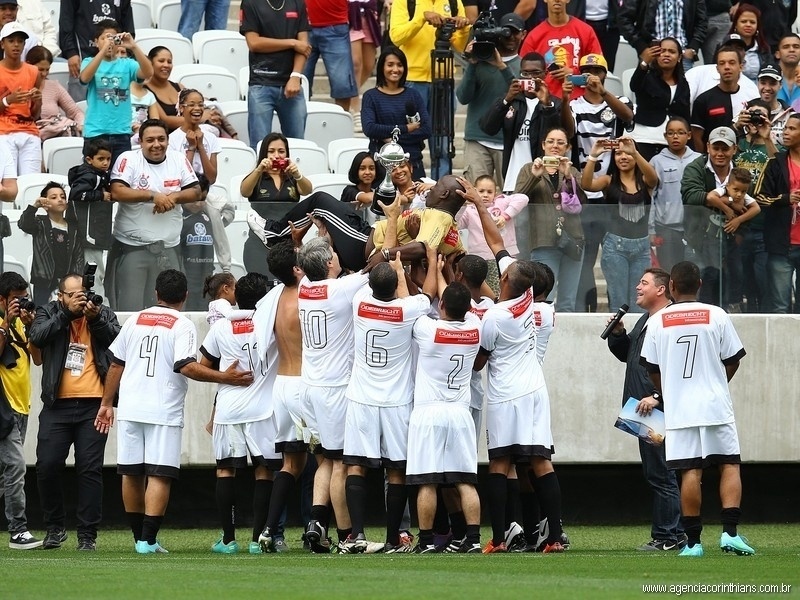 01.ami.2014 - Funcionários do Itaquerão comemoram e levantam taça simbólica após jogo teste do estádio