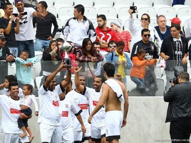 01.ami.2014 - Funcionários do Itaquerão levantam taça simbólica após jogo teste do estádio